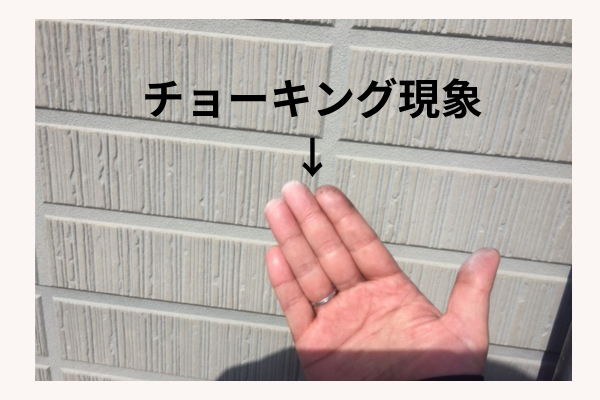 板野郡のお客様宅で外壁のチョーキングを手で確認している様子